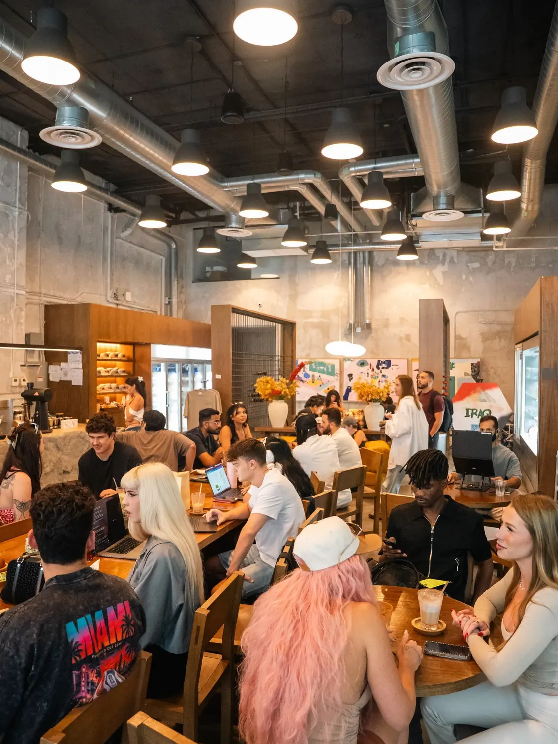 The room full of people at shared wooden tables